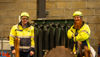 Two men in workwear next to a generator
