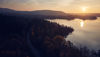 The sun sets over a forest on the Swedish coastline.