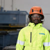 Stena Recycling expert standing in front of blue recycling containers