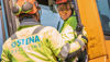 Two demolition experts in hardhats and protective jackets discussing building waste removal