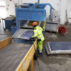 En Stena Recycling-medarbejder, der håndterer solceller, der skal genanvendes.